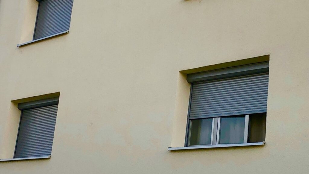 Dépannage volet roulant à Nice : façade avec volets roulants dont un bloqué à mi-hauteur