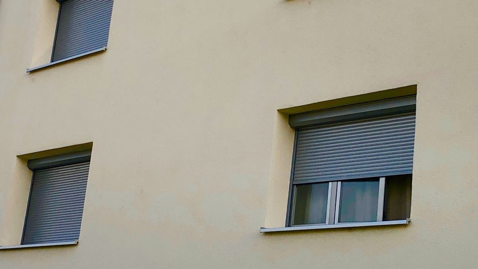 Dépannage volet roulant à Nice : façade avec volets roulants dont un bloqué à mi-hauteur